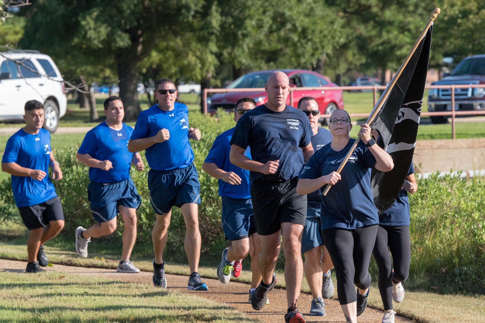 U.S. Air Force Airmen run with the POW/MIA flag at the Shellbank Fitness Center outdoor track on Joint Base Langley-Eustis, Virginia, Sept. 20, 2019.