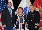DLA Installation Management’s Lisa Grenon (center) is awarded a 2019 Hart-Dole-Inouye Federal Center Service Award Nov. 8. Also pictured are DLA Disposition Services Director Mike Cannon and Battle Creek Military Affairs Committee Chairman T.R. Shaw, U.S. Navy, retired.
