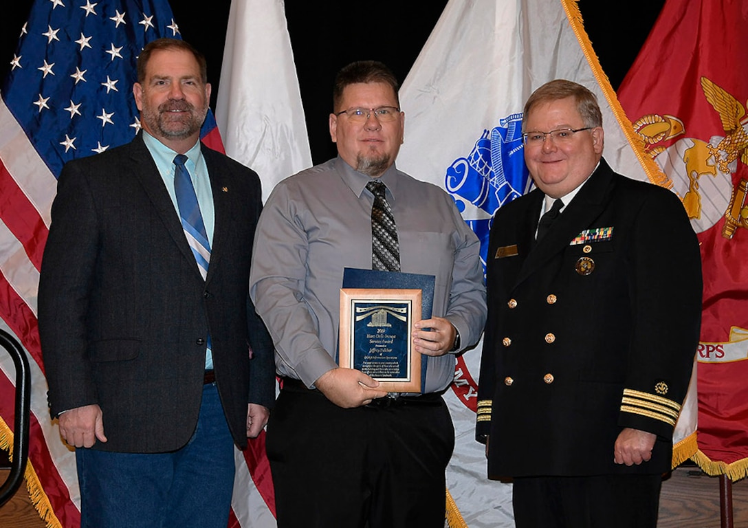 DLA Information Operations’ Jeff Fulcher (center) is awarded a 2019 Hart-Dole-Inouye Federal Center Service Award Nov. 8. Also pictured are DLA Disposition Services Director Mike Cannon and Battle Creek Military Affairs Committee Chairman T.R. Shaw, U.S. Navy, retired.