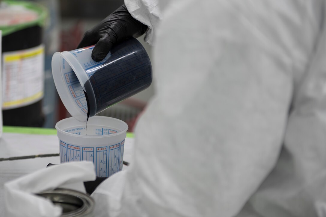 A photo of an Airman mixing paint