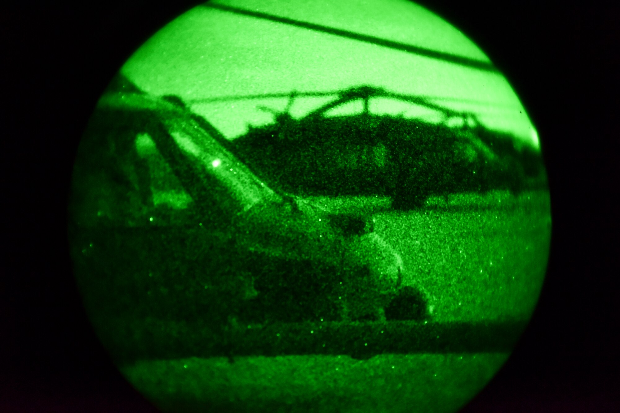 A night vision photo of two HH-60s sitting on a dirt runway.