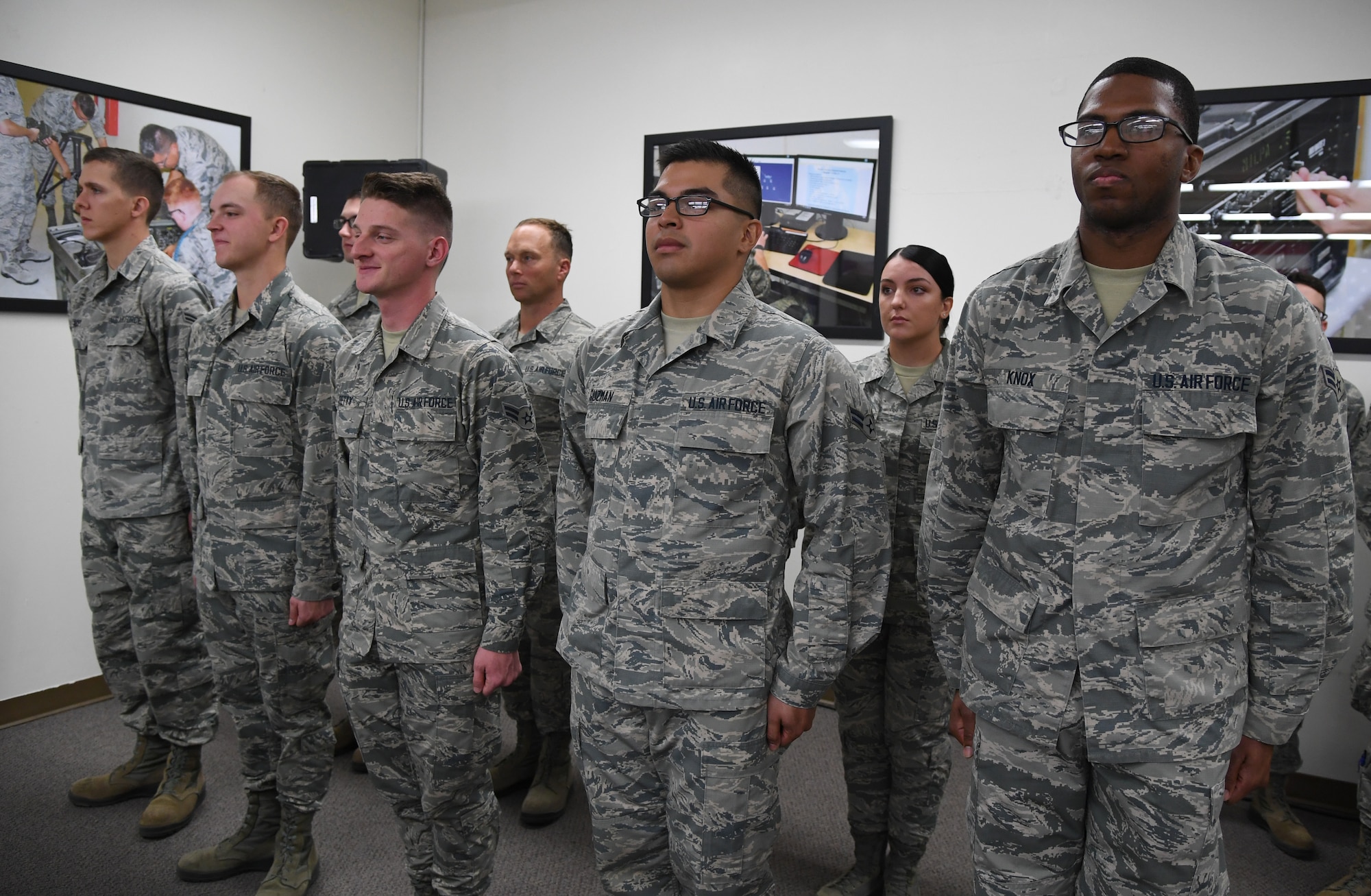 Airmen stand in formation during the 338th Training Squadron radio frequency transmission systems course graduation inside Jones Hall at Keesler Air Force Base, Mississippi, Nov. 8, 2019. Phil Bryant, Governor of Mississippi, presented certificates to the nine course graduates during the ceremony. (U.S. Air Force photo by Kemberly Groue)