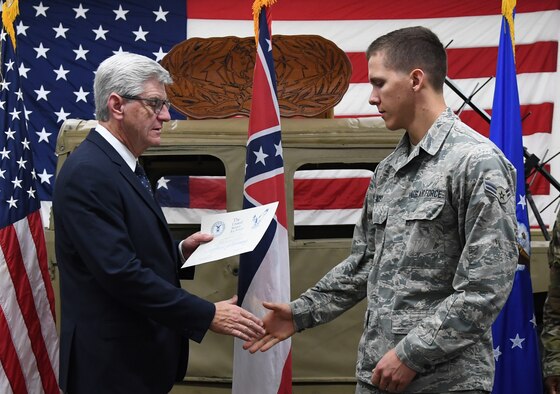 Phil Bryant, Governor of Mississippi, presents a graduation certificate to U.S. Air Force Airman 1st Class Weston Aces, 338th Training Squadron student, during the radio frequency transmission systems course graduation inside Jones Hall at Keesler Air Force Base, Mississippi, Nov. 8, 2019. Bryant presented certificates to the nine course graduates during the ceremony. (U.S. Air Force photo by Kemberly Groue)