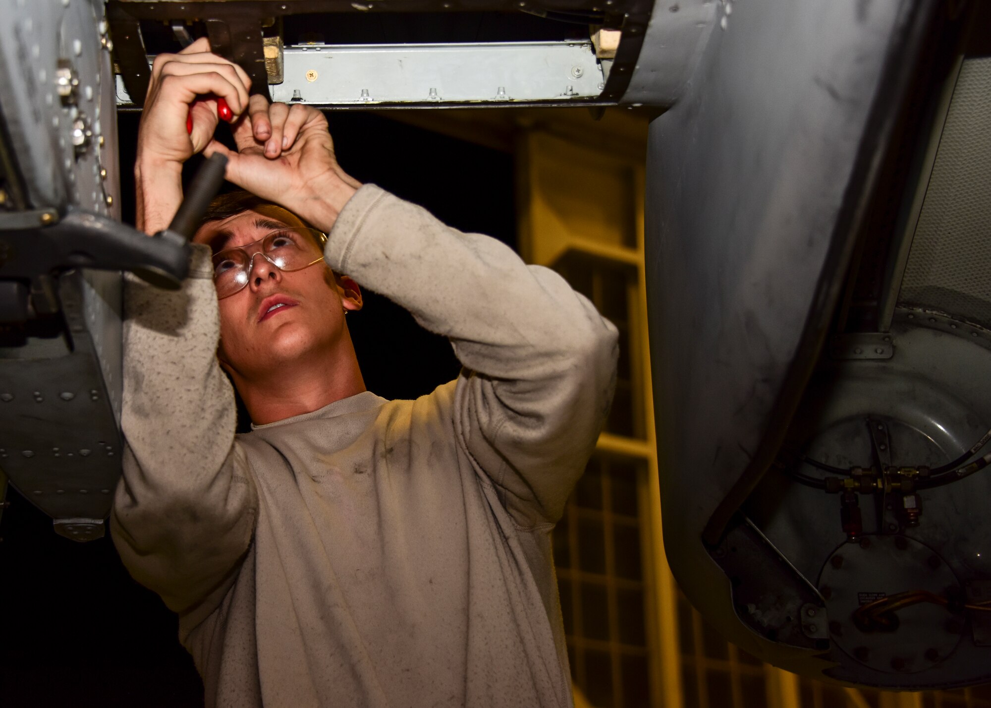 A photo of an airman working on a A-10.