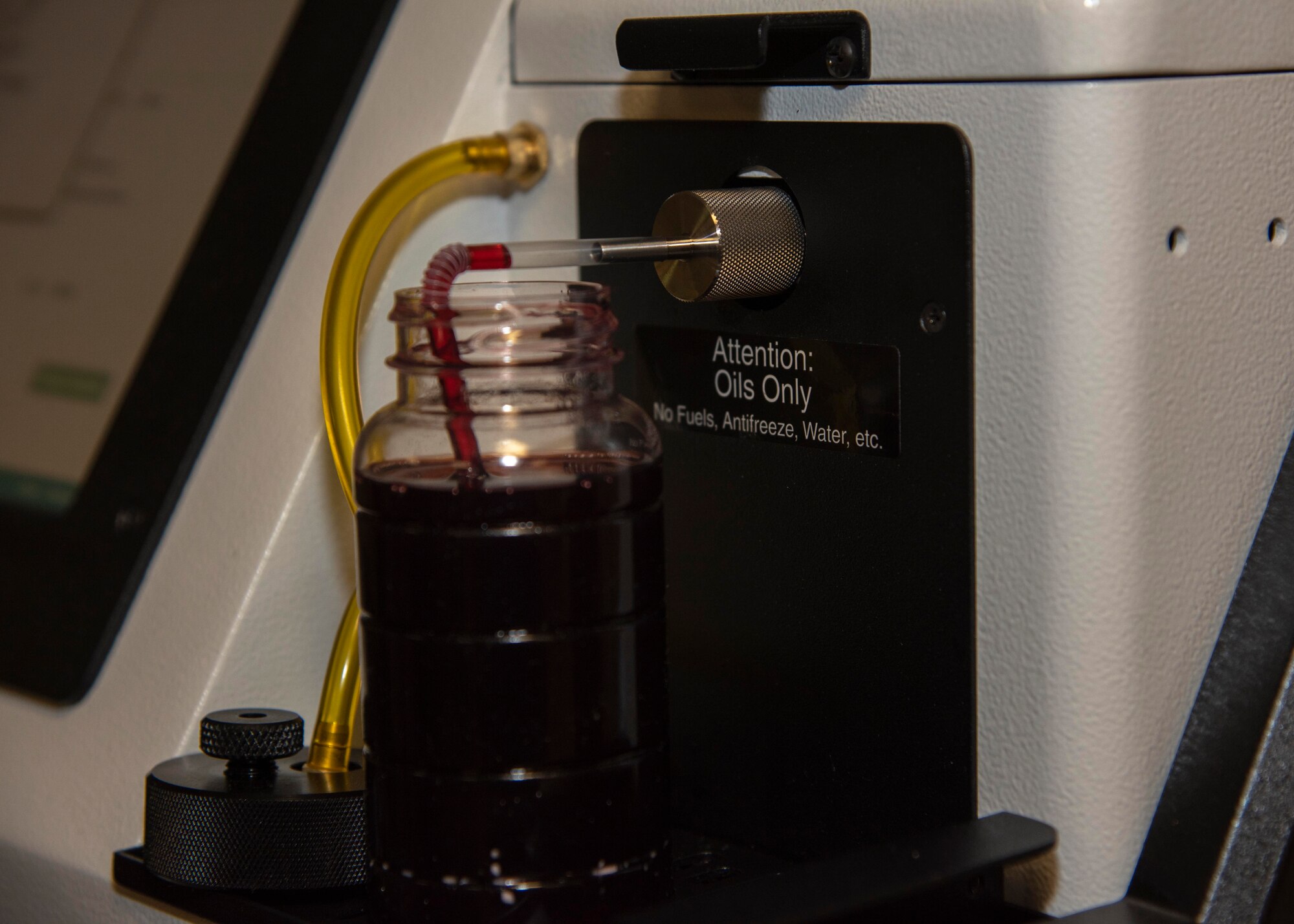 A sample of transmission fluid collected from a 92nd Logistics Readiness Squadron truck is analyzed at Fairchild Air Force Base, Washington, Nov. 4, 2019. Transmission fluid is just one of multiple machine oils the Micro Lab 40 Series is capable of analyzing to mitigate potential unnecessary routine oil changes, predict equipment failures to prevent future damage to vehicles and save money and man-hours. (U.S. Air Force photo by Airman Anneliese Kaiser)