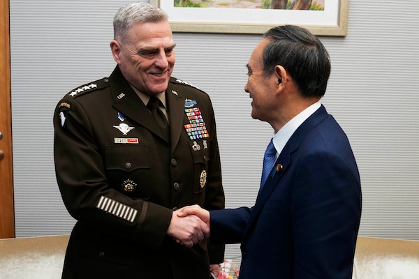 General and man in civilian suit shake hands.