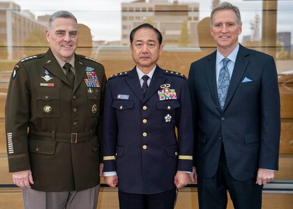 Three men pose for a photo.