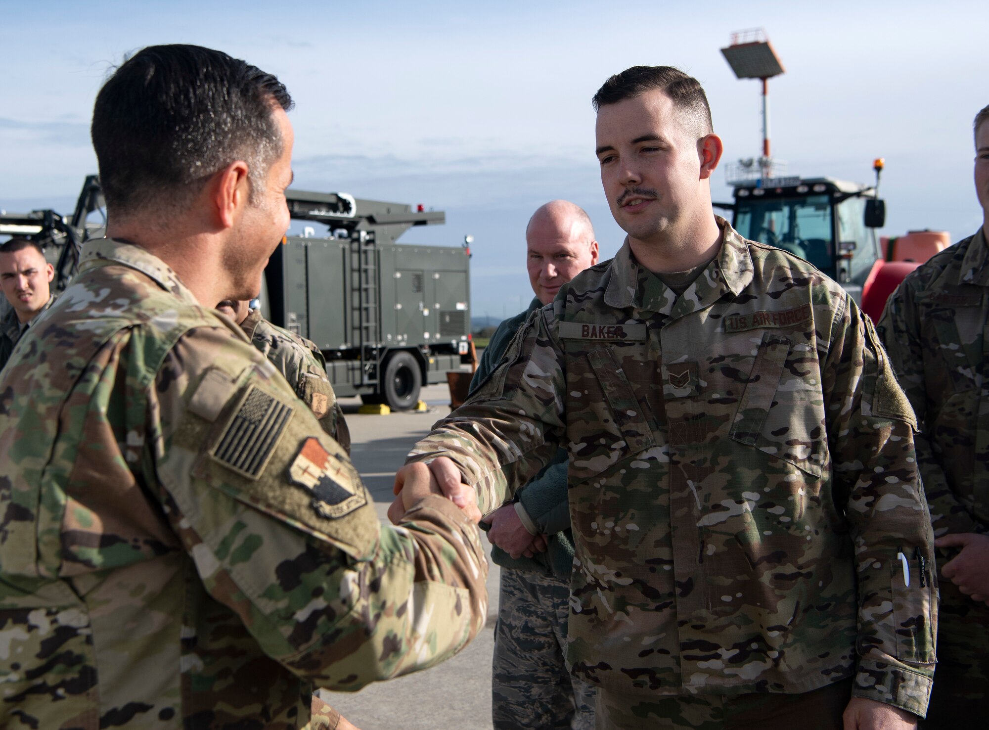 U.S. Air Force Col. Jason Hokaj, 52nd Fighter Wing vice commander, left, shakes hands with Staff Sgt. Nathan Baker, 52nd Logistics Readiness Squadron NCO in charge of vehicle maintenance, right, during a snow and ice parade at Spangdahlem Air Base, Germany, Nov. 8, 2019. The parade gave 52nd FW leadership a chance to become familiar with machinery used during inclement winter weather on the flightline. (U.S. Air Force photo by Staff Sgt. Preston Cherry)