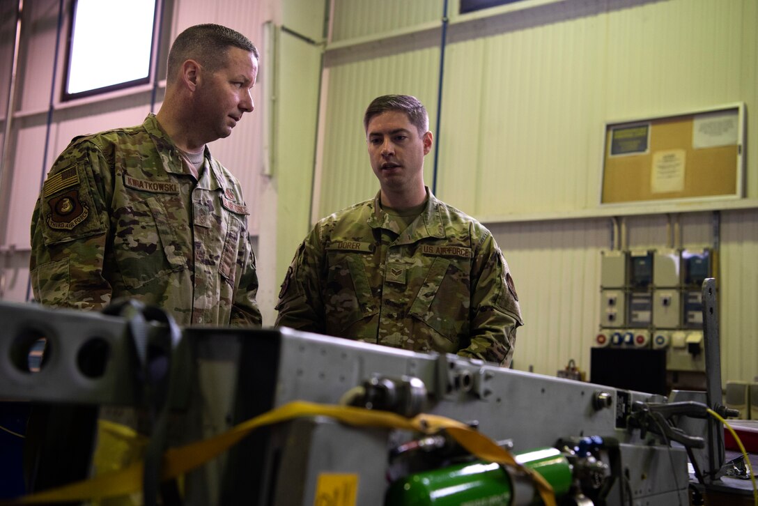 U.S. Air Force Chief Master Sgt. Randy Kwiatkowski, Third Air Force command chief, left, speaks with Senior Airman Blake Dorer, 52nd Maintenance Squadron egress systems journeyman, right, at Spangdahlem Air Base, Germany, Nov. 13, 2019. Kwiatkowski visited various locations around base to recognize Airmen for their efforts and learn about their everyday operations. The egress shop prepares Airmen for ejection procedures in case of an in-flight emergency. (U.S. Air Force photo by Airman 1st Class Valerie Seelye)
