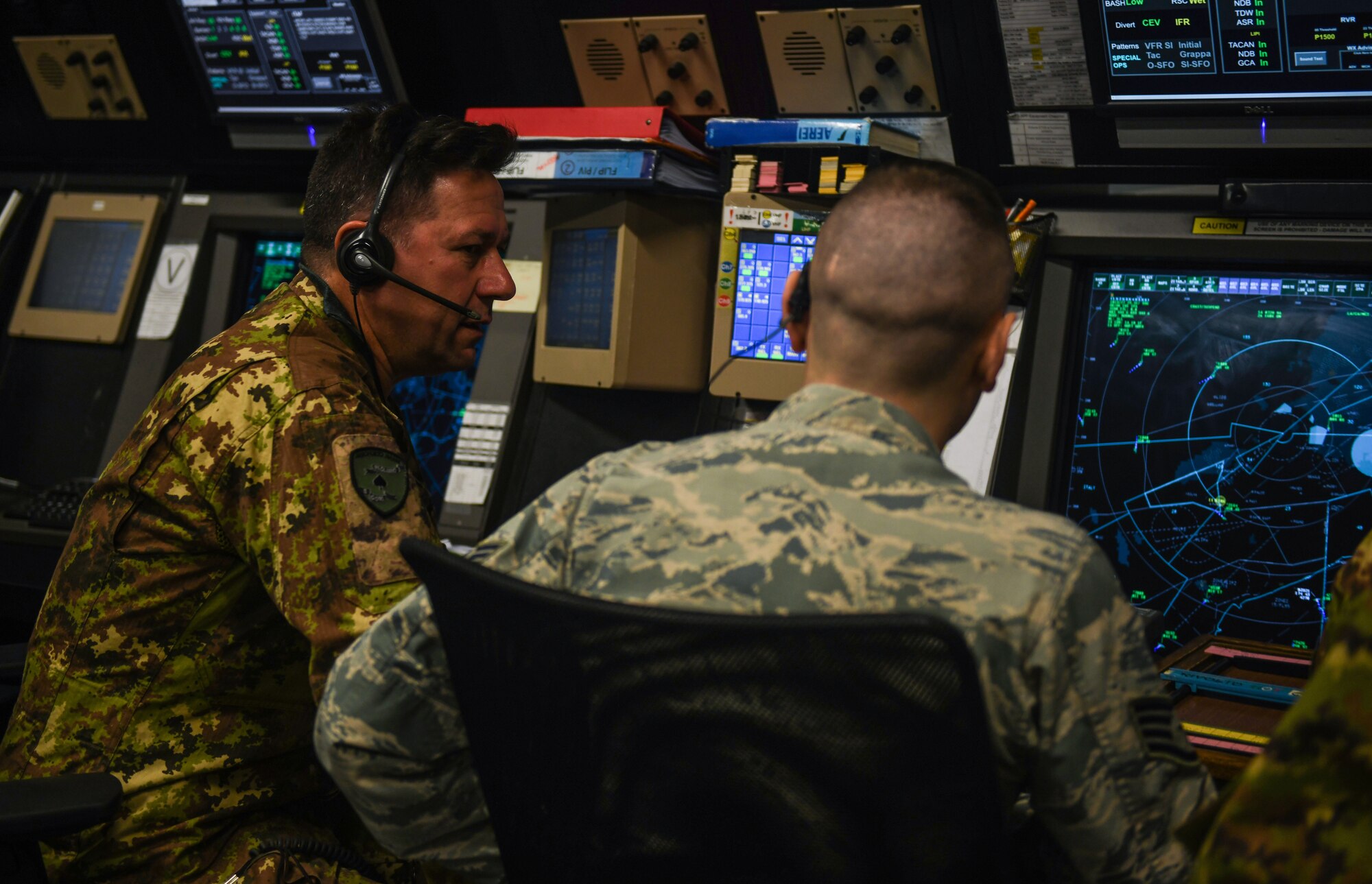 A U.S. Air Force Airman and an Italian Air Force Airman work together to sequence arriving and departing aircraft at Aviano Air Base, Italy, Nov. 13, 2019. The 31st Operations Support Squadron supports the 31st Fighter Wing combat-ready air control squadron, Guardian Angel rescue squadron, HH-60G Pave Hawk rescue squadron and two F-16CG Fighting Falcon fighter squadrons. (U.S. Air Force photo by Airman 1st Class Ericka A. Woolever).