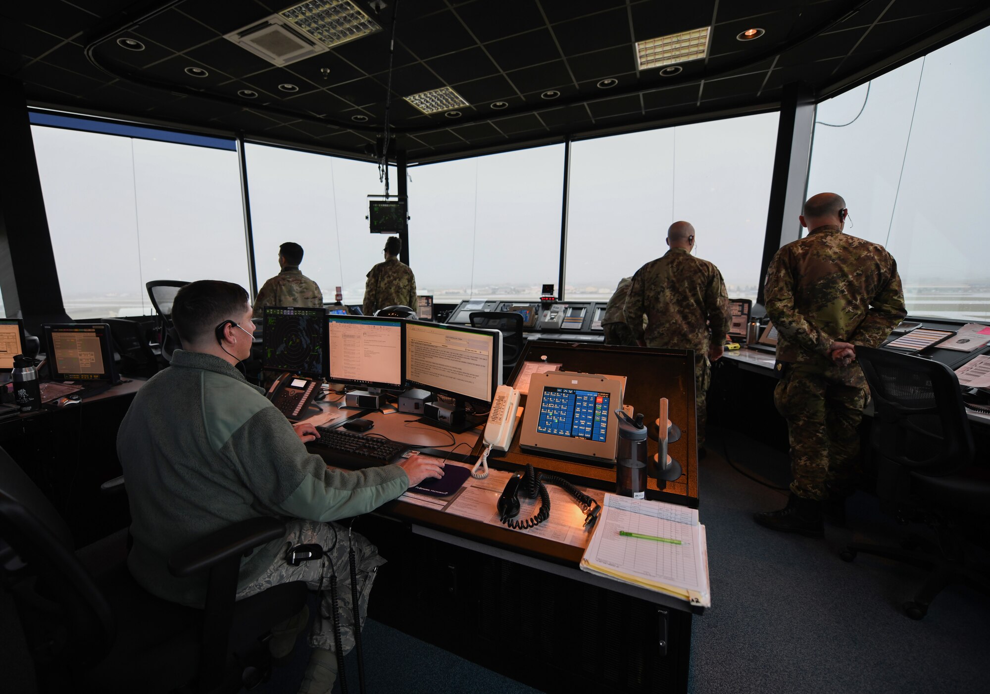 U.S. Air Force Airmen and Italian Air Force Airmen communicate with an inbound aircraft as they wait for an arrival at Aviano Air Base, Italy, Nov. 13, 2019. The 31st Operations Support Squadron develops wing war plans, administers weapons and tactics programs and provides current operations planning, air traffic control, airfield management, weather and intelligence support. (U.S. Air Force photo by Airman 1st Class Ericka A. Woolever).