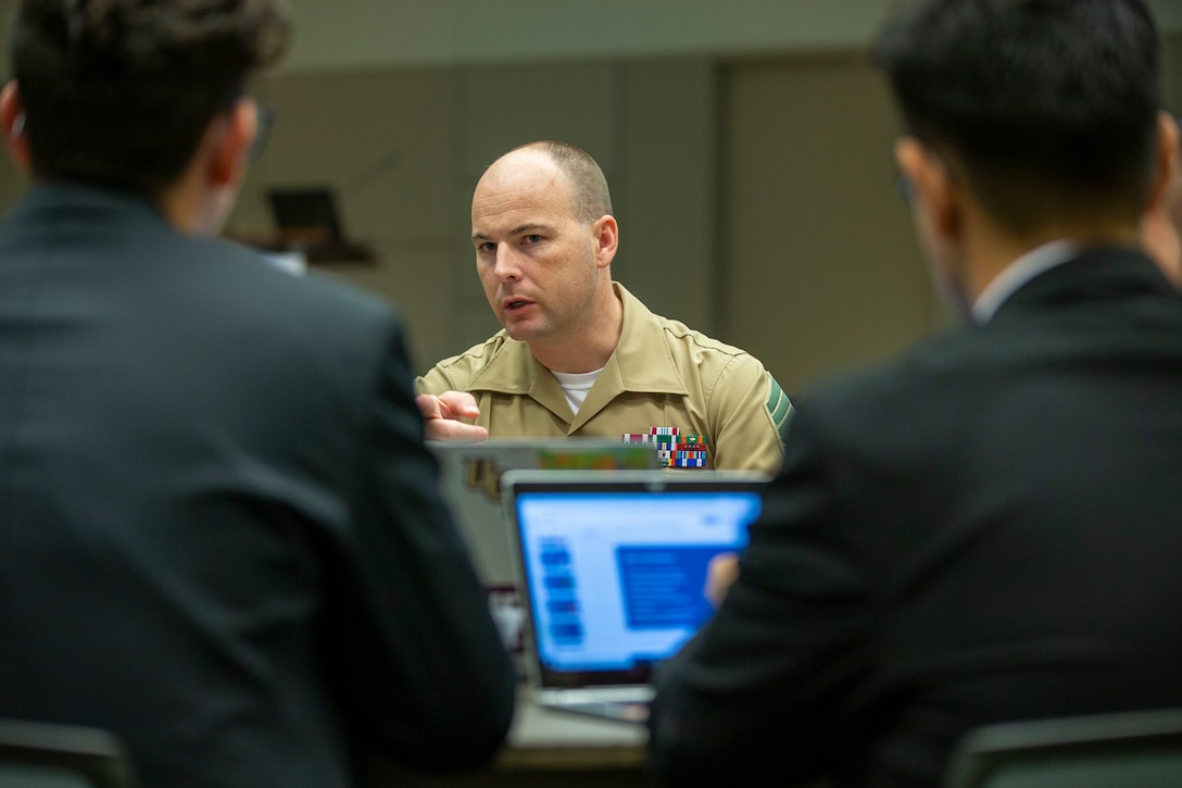 Master Sgt. Travis Hollingshead from Marine Corps Force Cyber Command talks to a group of students during the hackathon challenge at the 2019 Society of Hispanic Professional Engineers (SHPE) conference in Phoenix, Ariz., Oct. 31, 2019. SHPE is a national organization of professional engineers who serve as role models in the Hispanic community and aim to become leading innovators, scientists, mathematicians and engineers. The Hackathon challenge is a 48-56 hour event that focuses on coding, hacking, software development, critical thinking and problem solving. Through a partnership with SHPE, the Marines are looking to unlock the potential of those who possess a fighting spirit that allows them to overcome adversity while staying abreast of ever-changing technology to win any battle that faces our nation. (U.S. Marine Corps Photo by Sgt. Servante R. Coba)