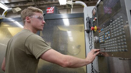 Senior Airman David Keys, 437th Maintenance Squadron, Fabrication Flight metals technology, turns on the computer numerical control machine Oct. 25, 2019, at Joint Base Charleston, S.C. The CNC drills, bores and lathes C-17 parts. The fabrication flight completes approximately 5,900 C-17 repairs annually.
