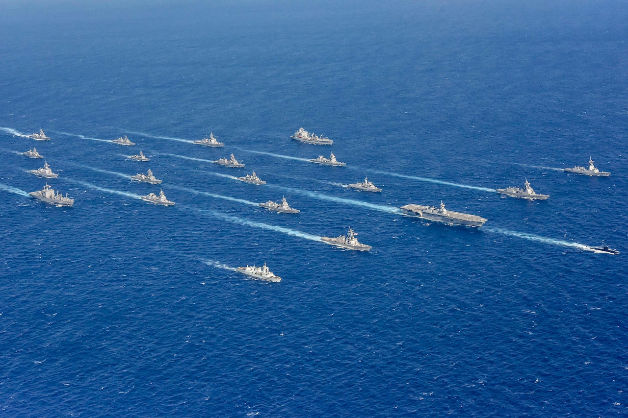 A large group of ships sail in formation.