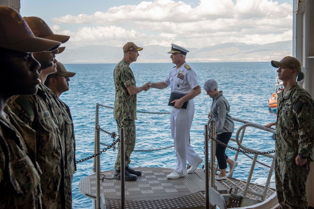U.S. Navy Capt. Charles Cather, left, assigned to the hospital ship USNS Comfort (T-AH 20), welcomes Adm. Craig S. Faller, commander, U.S. Southern Command, to the ship while it is anchored off the coast of Port-Au-Prince, Haiti, Nov. 7, 2019.