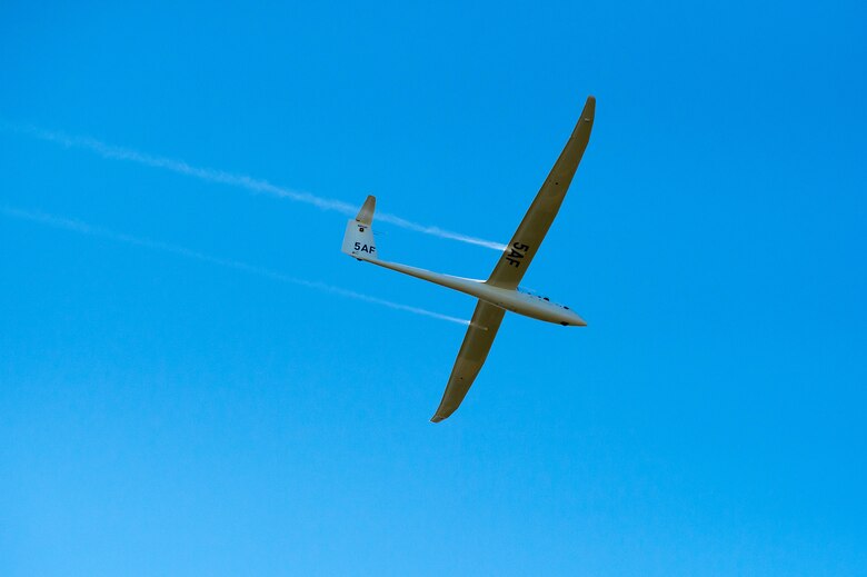 An Air Force Academy cadet piloting a glider performs during the Parents' Weekend Parade, Aug. 22, 2019, at the U.S. Air Force Academy, Colo. The Academy's aerobatics team uses the TG-16A Glider, a two-seat, engine-less glider. The glider is towed to a designated altitude by a Piper Super Cub tow plane before being released and soaring in-flight by using thermals and prevailing winds. (U.S. Air Force photo/Trevor Cokley)
