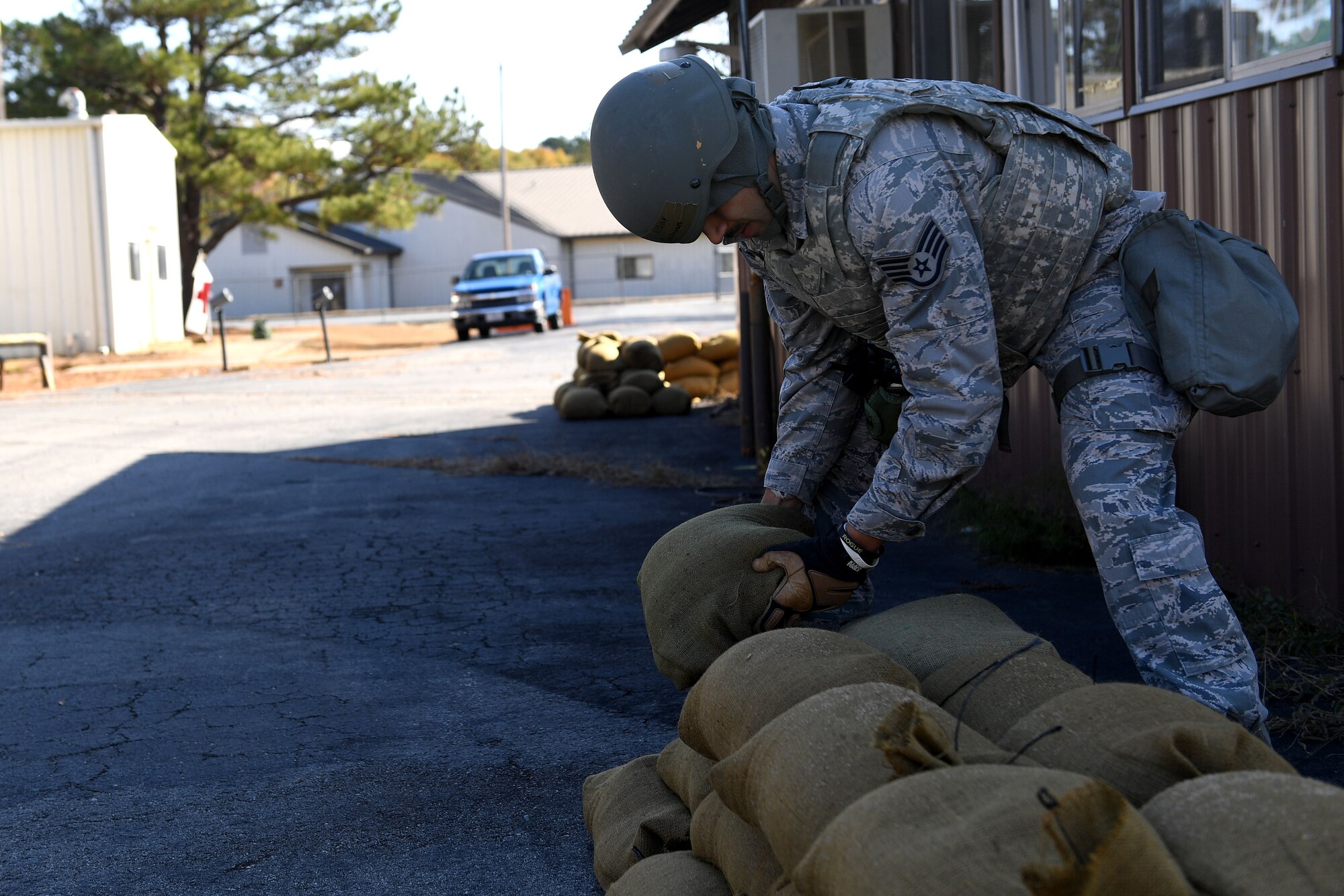 An Airman lays down sandbags