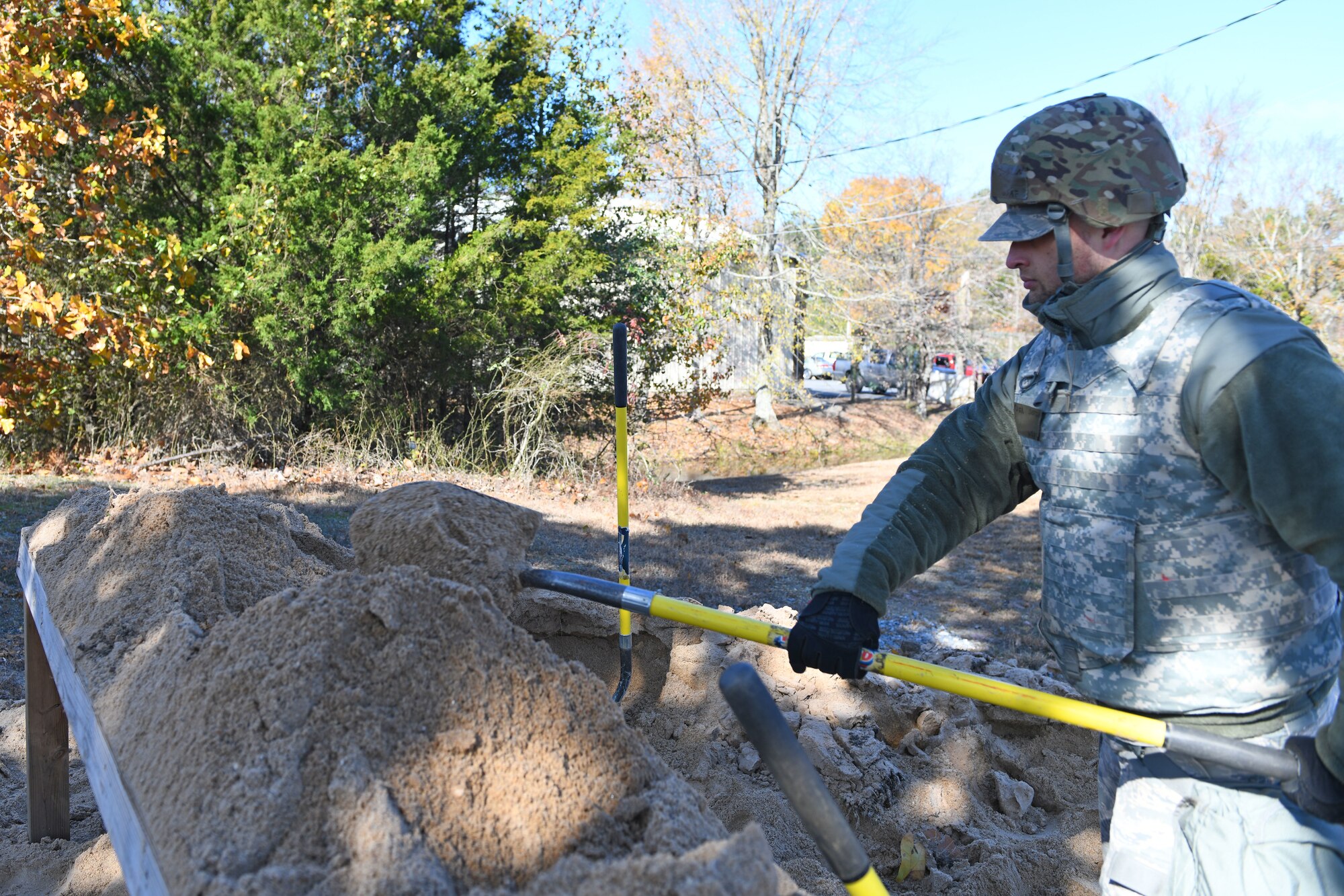 An Airman shovels sand