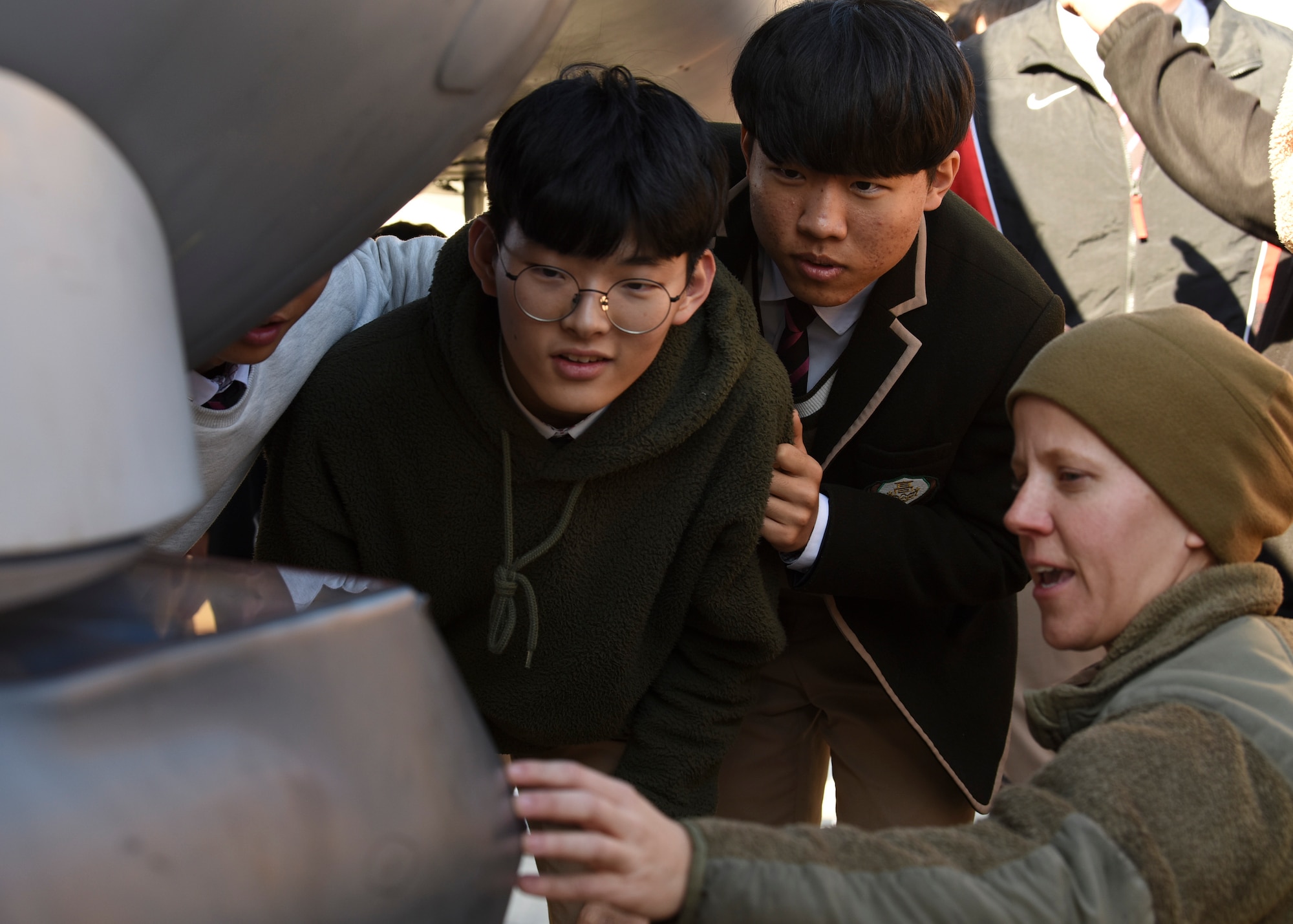 U.S. Air Force Tech. Sgt. Sarah Allen, 35th Aircraft Maintenance Unit electric and environmental craftsman, tells students from Gunsan Dong High School about the capabilities of the F-16 Fighting Falcon during a tour at Kunsan Air Base, Republic of Korea, Nov. 8, 2019. This was the first time the students were able to visit Kunsan and get up close and personal with an F-16. (U.S. Air Force photo by Staff Sgt. Anthony Hetlage)