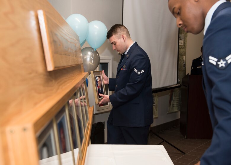 Two Airmen place plaques into a wooden fixture during a ceremony, Nov. 11, 2019, at Mountain Home Air Force Base, Idaho. The fixture is part of a legacy wall within the 366th Fighter Wing used to document and honor prior command chiefs. (U.S. Air Force photo by Senior Airman Tyrell Hall)
