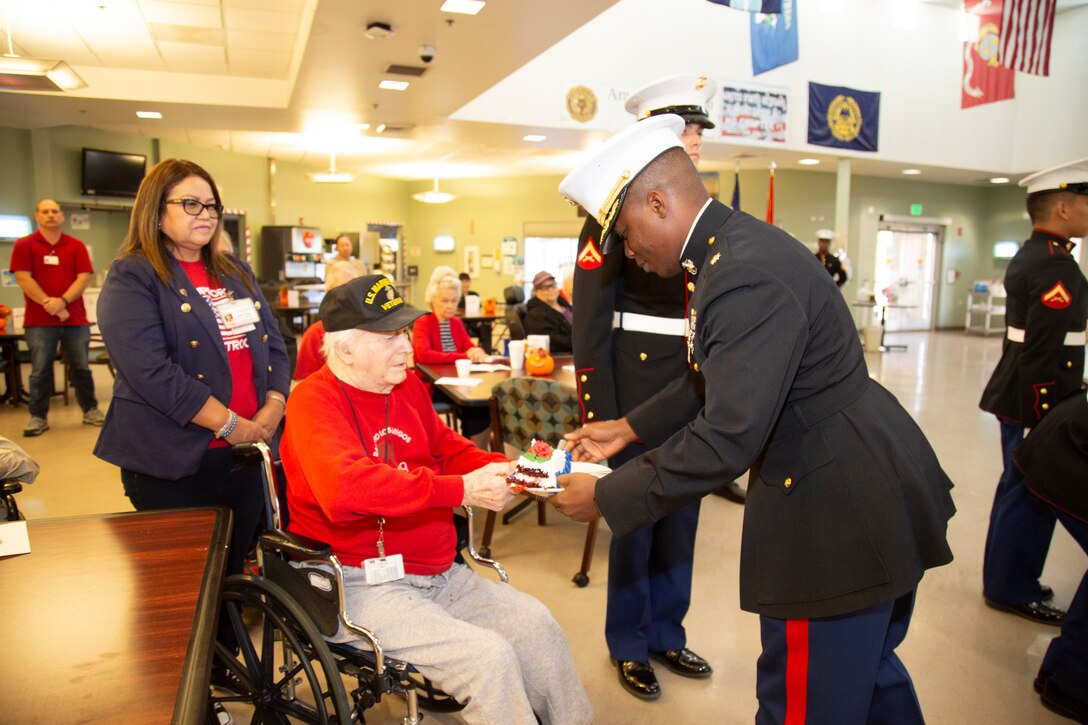 Major Ernest Robinson, Headquarters Company commanding officer and Base Operations officer from Marine Corps Logistics Base Barstow, hands the first piece of birthday cake to the oldest Marine, Arthur Monde, at the tender age of 94, present during the U.S. Marine Corps’ birthday celebration at the Veterans Home of  California - Barstow, Calif., Nov. 8. Traditionally the first piece of cake is served to the oldest Marine then the youngest Marine present at the ceremony. Youngest Marine present at the ceremony was 19-year old Lance Cpl. Noah Avila, data systems administrator for MCLB Barstow.