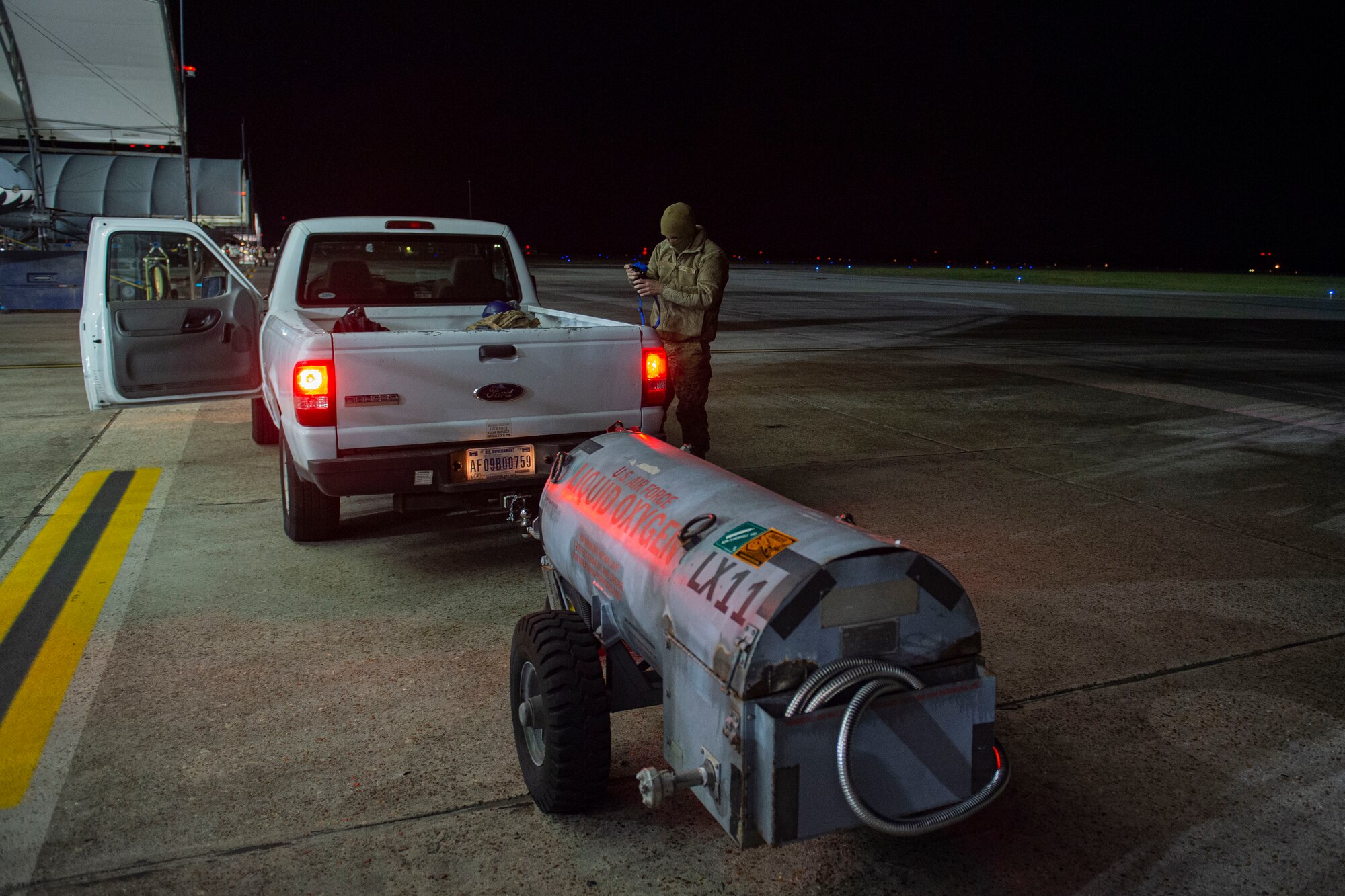 A photo of an Airman disconnecting a liquid oxygen tank from a truck