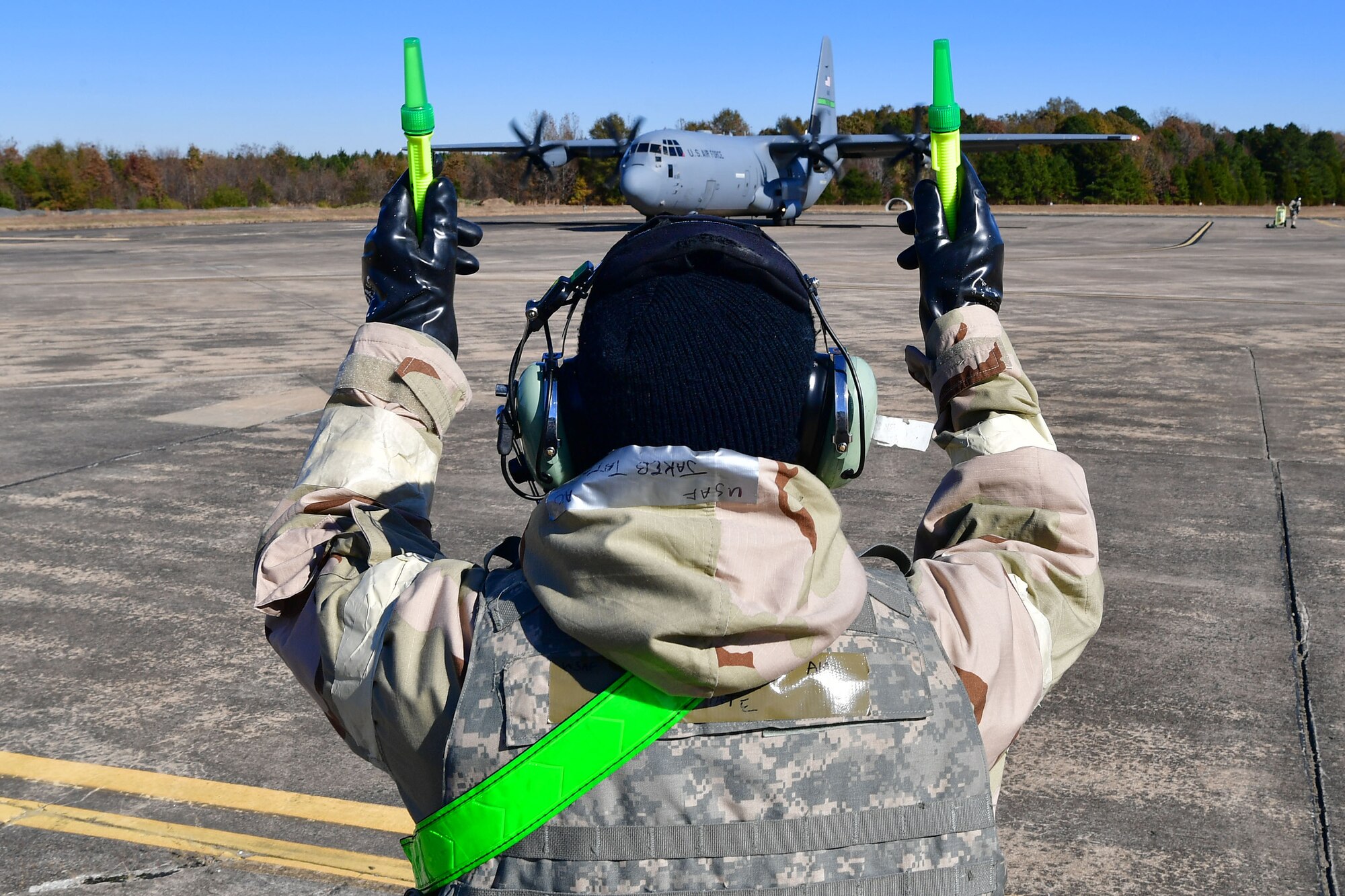 An Airman marshals a C-130 plane