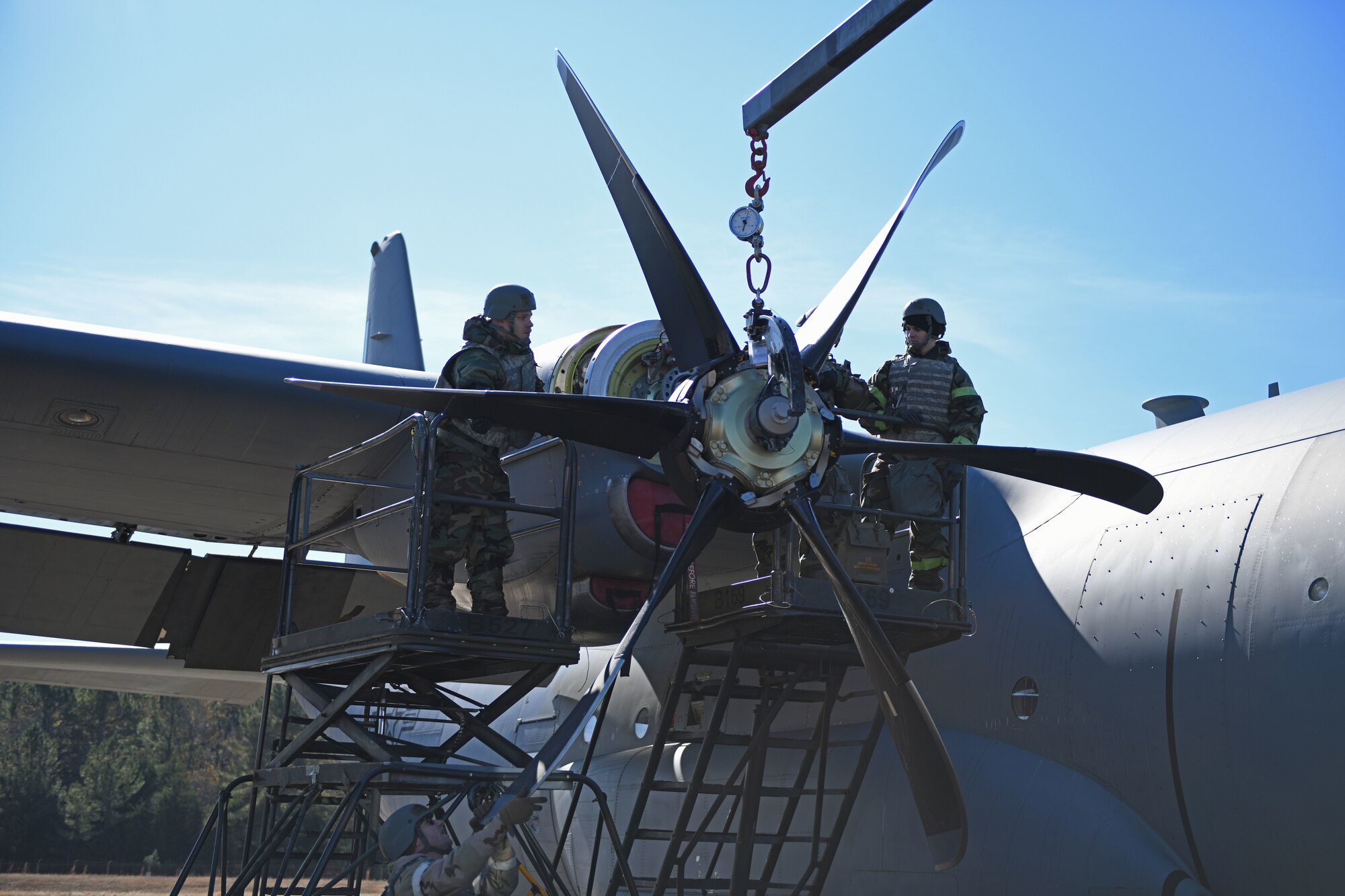 Airmen put a propeller on a C-130J