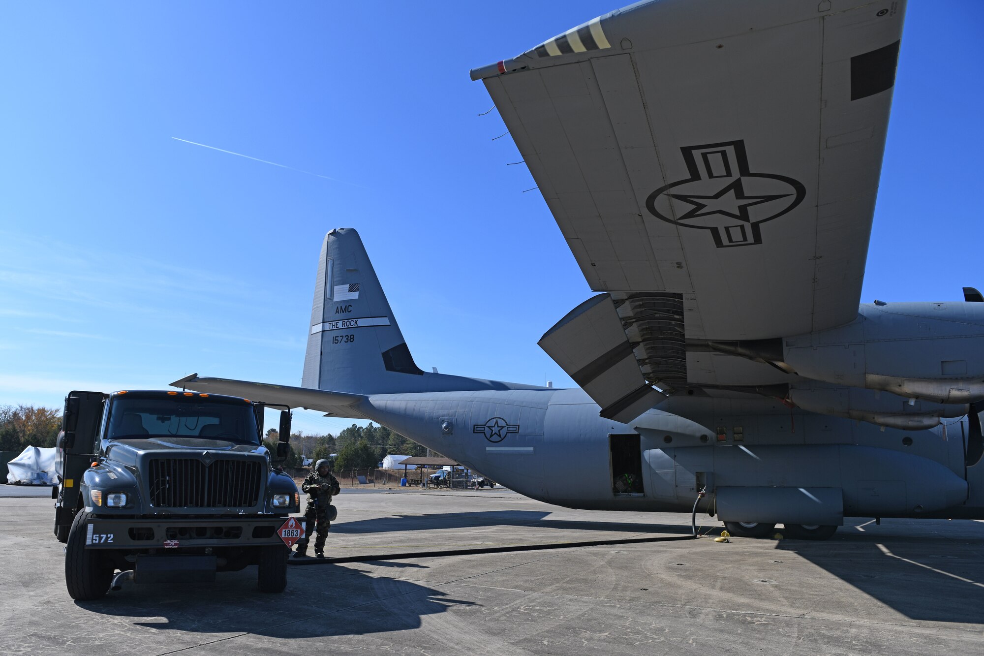 Airmen put gas in a C-130J