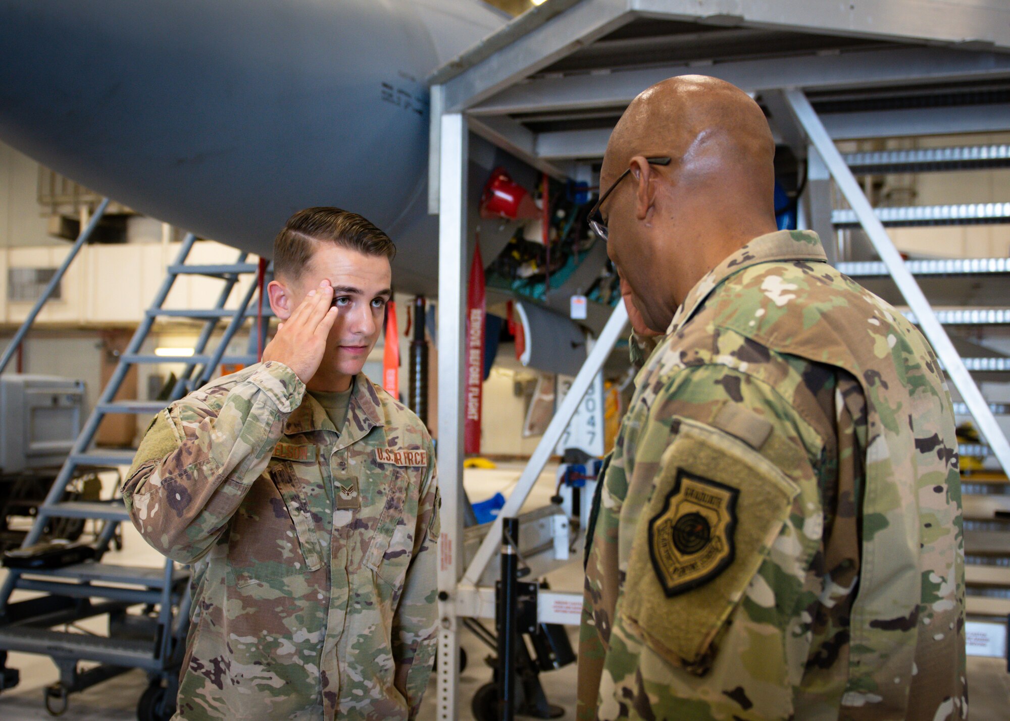 U.S. Air Force Senior Airman Robert Nickelson, 18th Munitions Squadron precision guided munitions crew chief, salutes after being coined by Gen. CQ Brown, Jr., Pacific Air Forces commander, at Kadena Air Base, Japan, Nov. 12, 2019. During the tour, Brown coined Airmen from different units as a way of thanks and recognition of their superior performance. (U.S. Air Force photo by Staff Sgt. Benjamin Raughton)