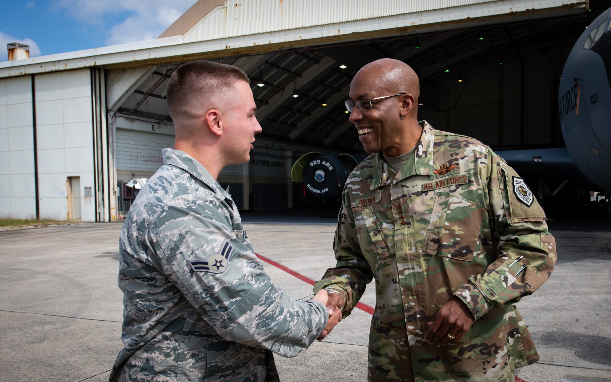 U.S. Air Force Gen. CQ Brown, Jr., Pacific Air Forces commander, coins Airman 1st Class Tucker Heyduk, 18th Civil Engineer Squadron barrier maintenance technician, during a tour at Kadena Air Base, Japan, Nov. 12, 2019. During the tour, Brown coined Airmen from different units as a way of thanks and recognition of their superior performance. (U.S. Air Force photo by Staff Sgt. Benjamin Raughton)