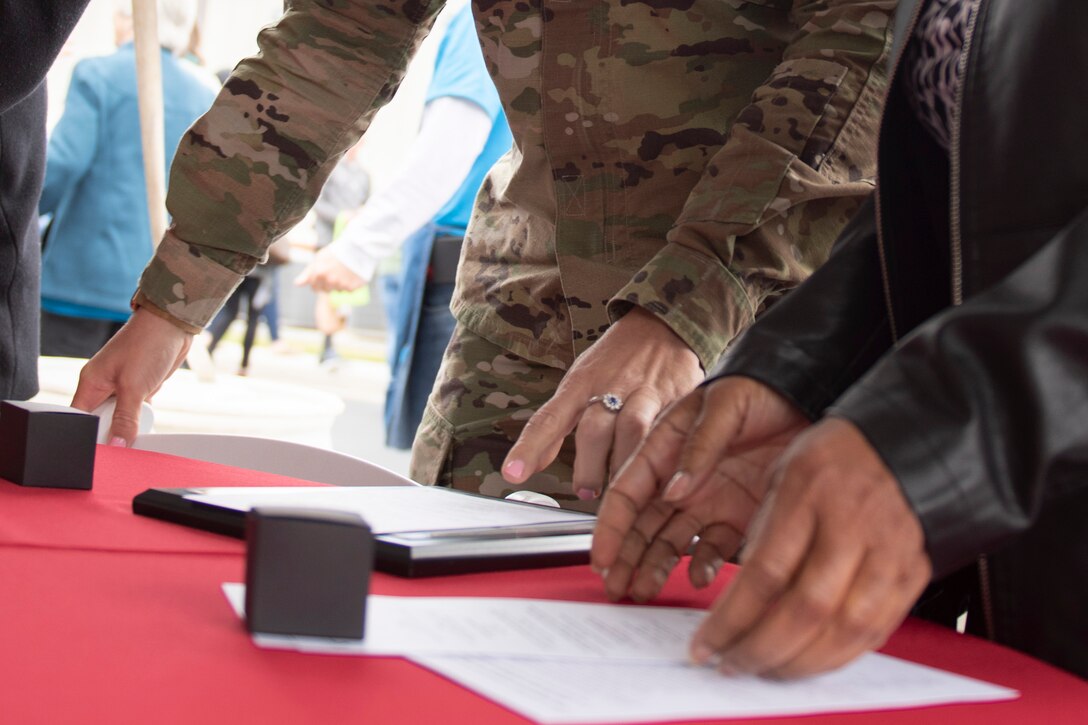 A photo of an Airman and people from the local community looking at an award during an event