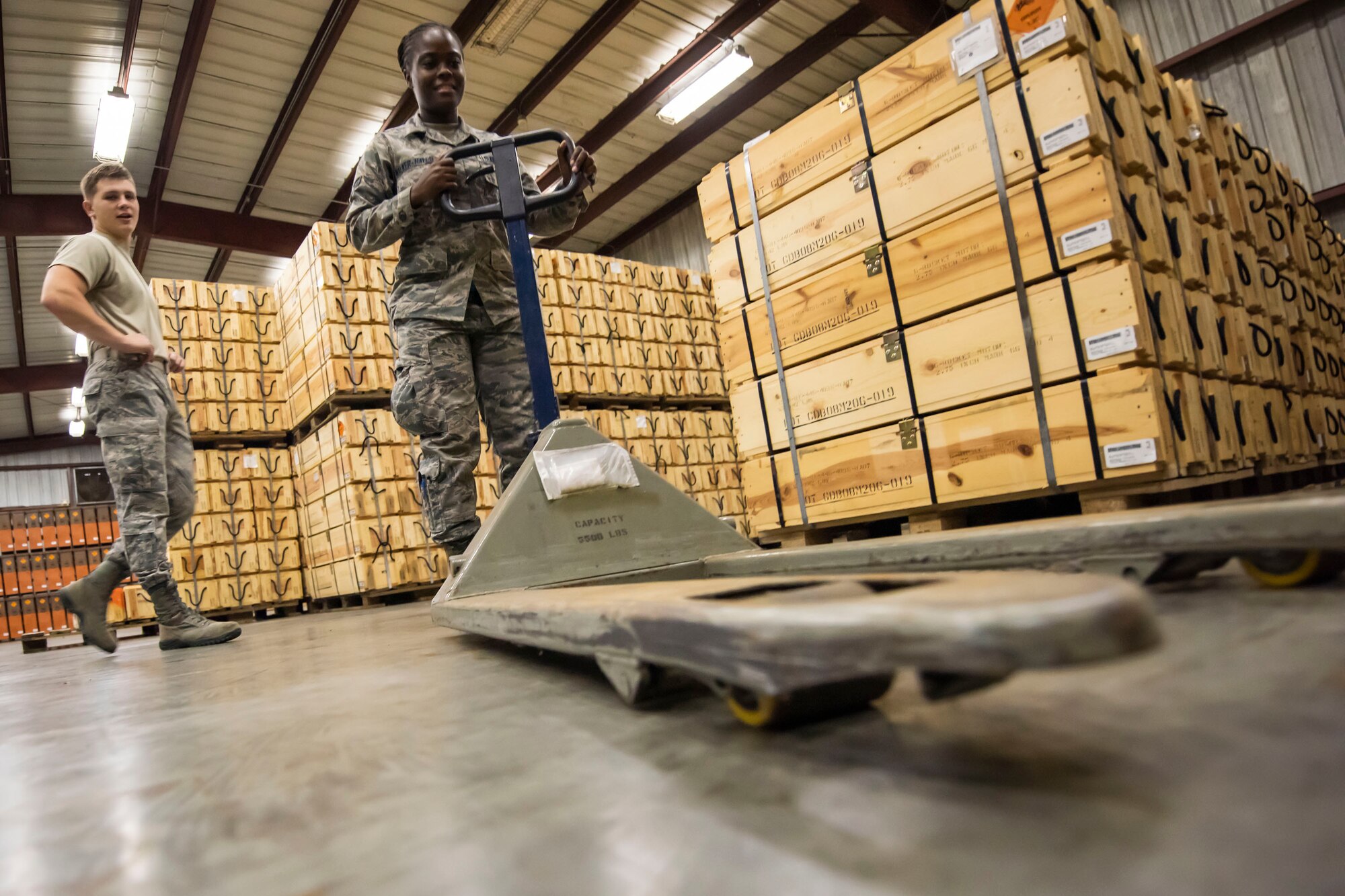 A photo of an Airman moves a pallet jack used for munitions transport