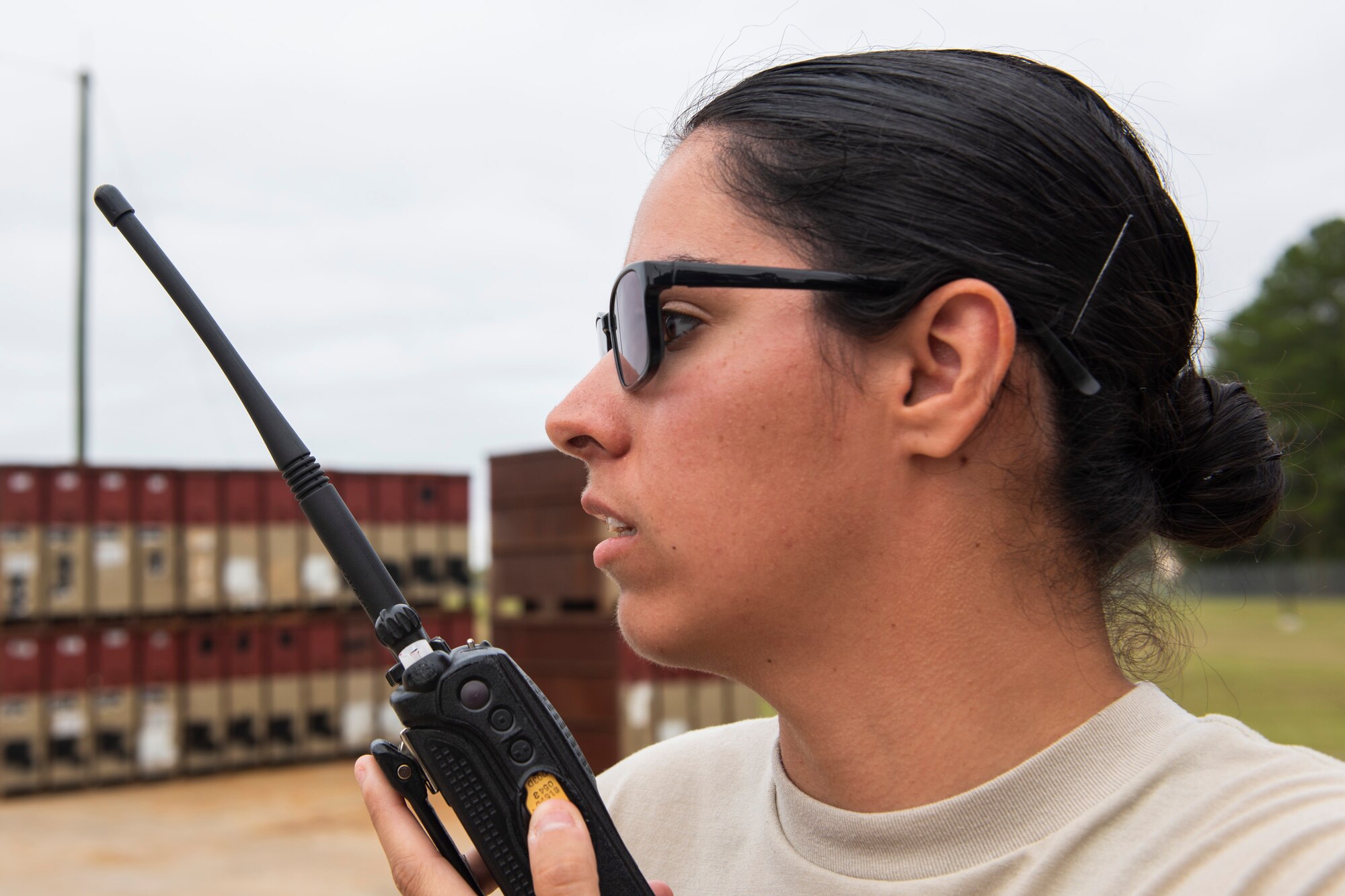 A photo of an Airman using a radio to talk to another Airmen