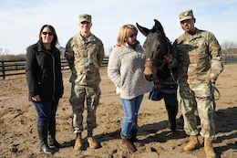 Theresa Scott, family readiness support assistant, 1st TSC, Capt. Mark H. Schneider, Headquarters and Headquarters Company (HHC) Commander, 1st TSC,  Kristen Small, 1st TSC SFRG co-leader and key caller and Blackjack's handler, Sgt. Amir Bullock, information technology assistant, 1st TSC, gather for a group photo with Blackjack on Nov. 13, 2019 at his home in Simpsonville, Ky.