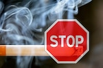 Image of lit cigarette with a stop sign.