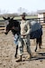 Blackjack's handler, Sgt. Amir Bullock, information technology specialist, 1st Theater Sustainment Command, leads Blackjack on a walk around the arena during a visit to the mascot's home in Simpsonville, Ky. on Nov. 13, 2019.