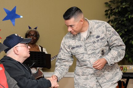 Staff Sgt. Victor Medina-Ornelas, 343rd Training Squadron Block One Instructor, shakes the hand of a veteran at a Veterans Day ceremony at Legend Oaks Healthcare and Rehabilitation in San Antonio Nov. 8.