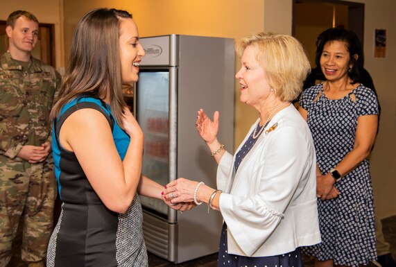 Dawn Goldfein, wife of Air Force Chief of Staff Gen. David L. Goldfein, coins a spouse of Team Andersen during her visit to the United Service Organizations at Andersen Air Force Base, Guam, Aug. 15, 2019. During her visit, Dawn learned how the USO helps support members of Team Andersen. (U.S. Air Force photo by Airman 1st Class Michael S. Murphy)