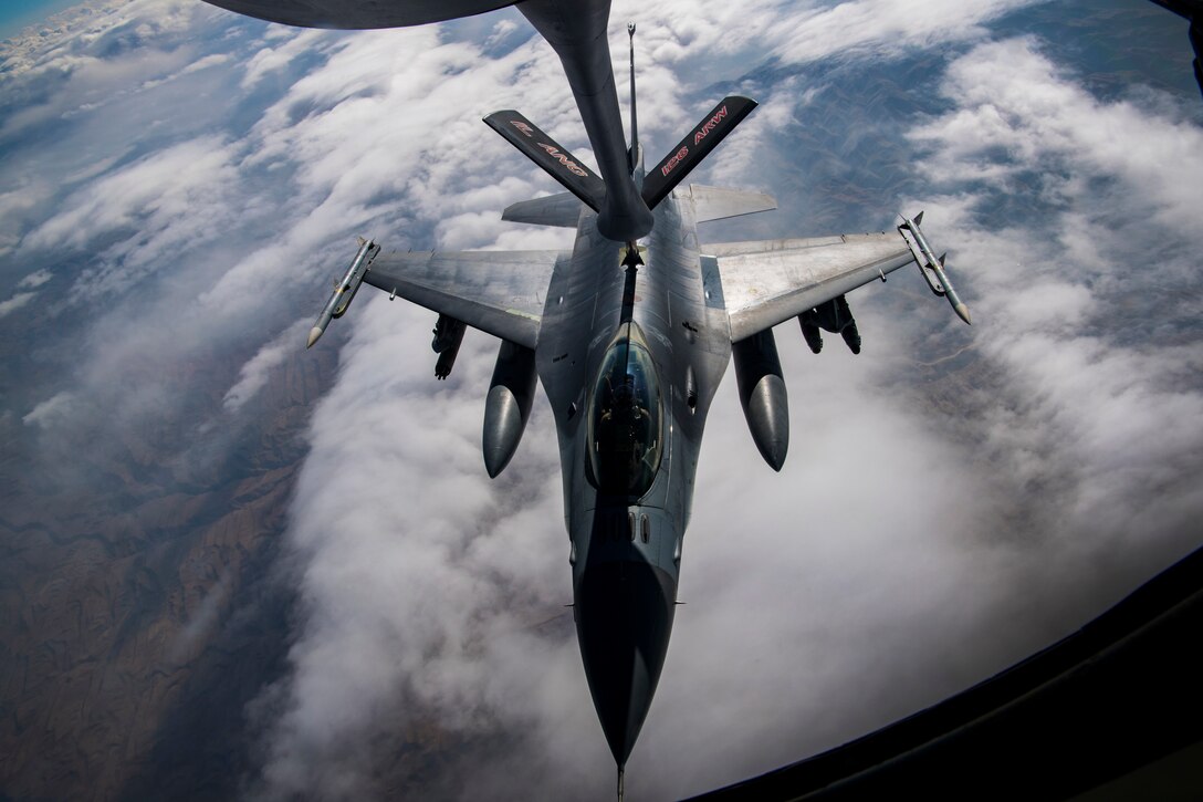 A military aircraft is refueled in midair.