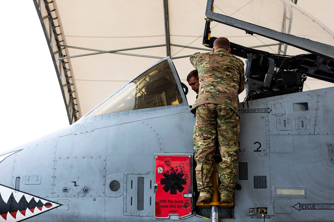 A photo of an Airman prepping a pilot for a flight.