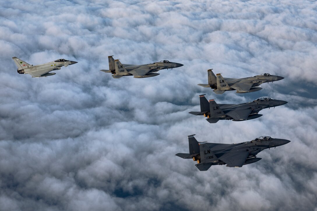 Five military aircraft fly in formation.