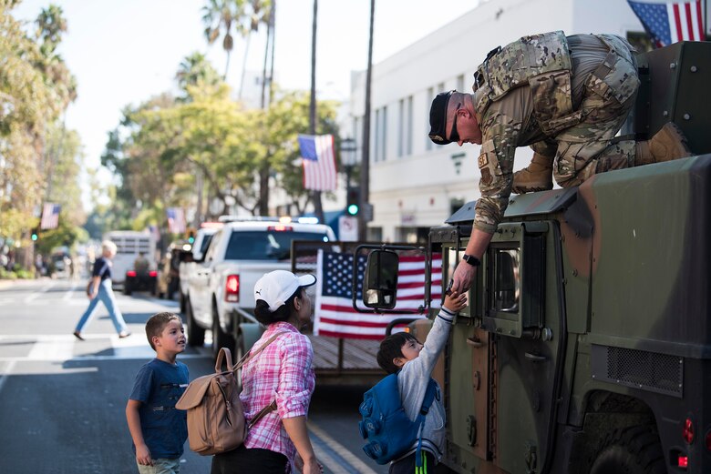 Tech. Sgt. John Townsend, 30th Security Forces Squadron non-commissioned officer in charge of launch operations support, hands out candy to children during the Santa Barbara Veterans Day Parade Nov. 9, 2019, in Santa Barbara, Calif. Veterans Day was approved as a national holiday on June 1, 1954, as a day to honor American veterans of all wars, and is celebrated on Nov. 11. (U.S. Air Force photo by Airman 1st Class Hanah Abercrombie)
