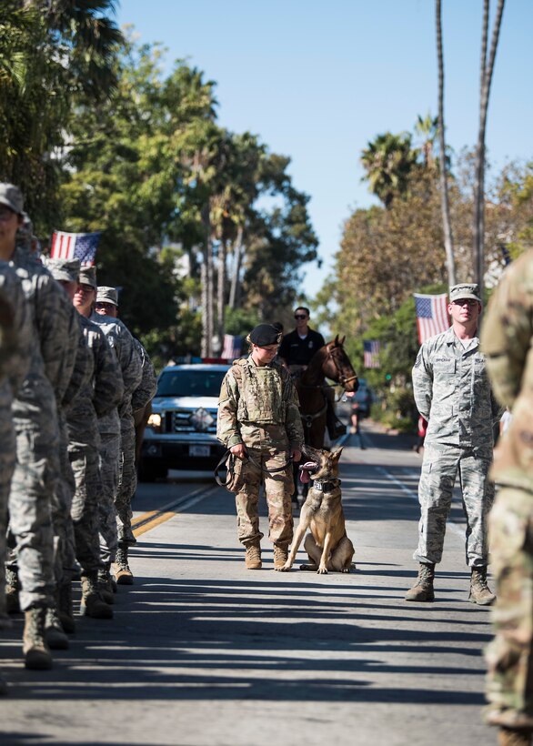 Staff Sgt. Tiffany Core, 30th Security Forces Squadron military working dog handler, stands with MWD Dani during the Santa Barbara Veterans Day Parade Nov. 9, 2019, in Santa Barbara, Calif. During the parade, Vandenberg displayed two flights of Airmen, Military Working Dogs, Military Working Horses, honor guard and a variety of military vehicles. (U.S. Air Force photo by Airman 1st Class Hanah Abercrombie)