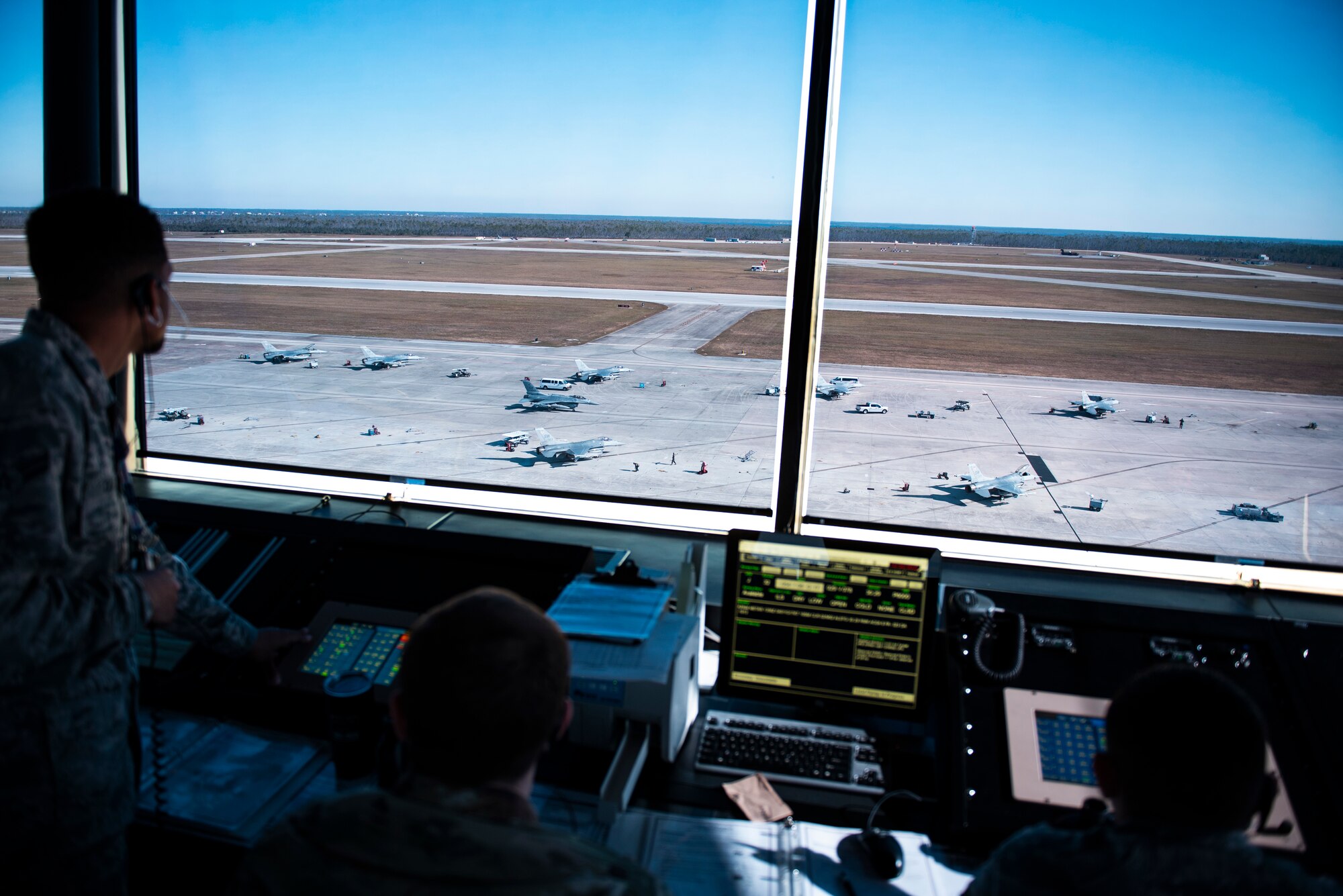 Airman 1st Class Treyzhaun, left, Senior Airman Ryan Breton, center, and A1C Jose Gallardo, right, 325th Operations Support Squadron, air traffic controllers, communicate with inbound and outbound pilots trafficking the runway in support of exercise Checkered Flag 20-1 at Tyndall Air Force Base, Florida, Nov. 13, 2019. Checkered Flag is a large-scale exercise involving multiple military partners and installations, designed to focus on training and evaluating fourth and fifth-generation fighter aircraft, pilots and maintainers. In conduction with the exercise, air-to-air and air-to-ground combat operations are tested and recorded to provide data on best practices and ensuring future mission successes. (U.S. Air Force photo by Staff Sgt. Magen M. Reeves)