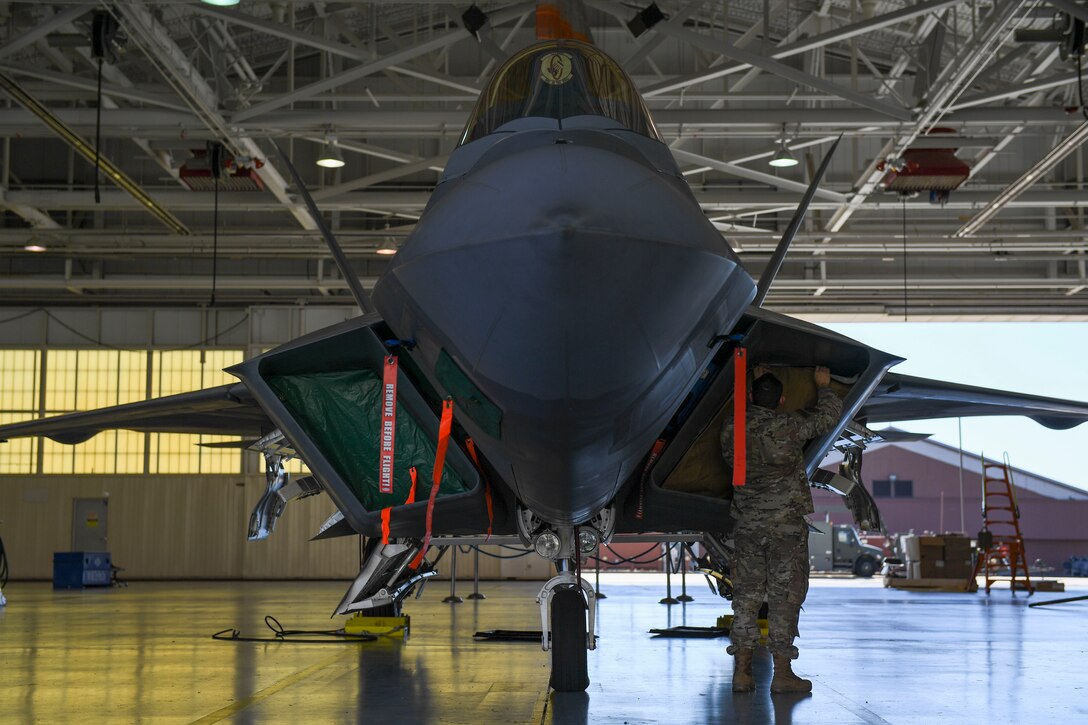 U.S. Air Force Tech. Sgt. Daniel Caban, 1st Aircraft Maintenance Squadron crew chief, secures a portion of the Portable Magnetic Aircraft Covers to an F-22 Raptor intake at Joint Base Langley-Eustis, Virginia, Oct. 23, 2019.