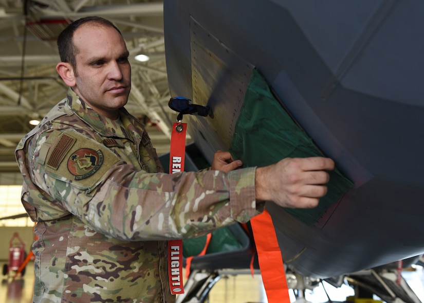 U.S. Air Force Tech. Sgt. Daniel Caban, 1st Aircraft Maintenance Squadron crew chief, covers part of an F-22 Raptor with a portion of the Portable Magnetic Aircraft Covers at Joint Base Langley-Eustis, Virginia, Oct. 23, 2019.