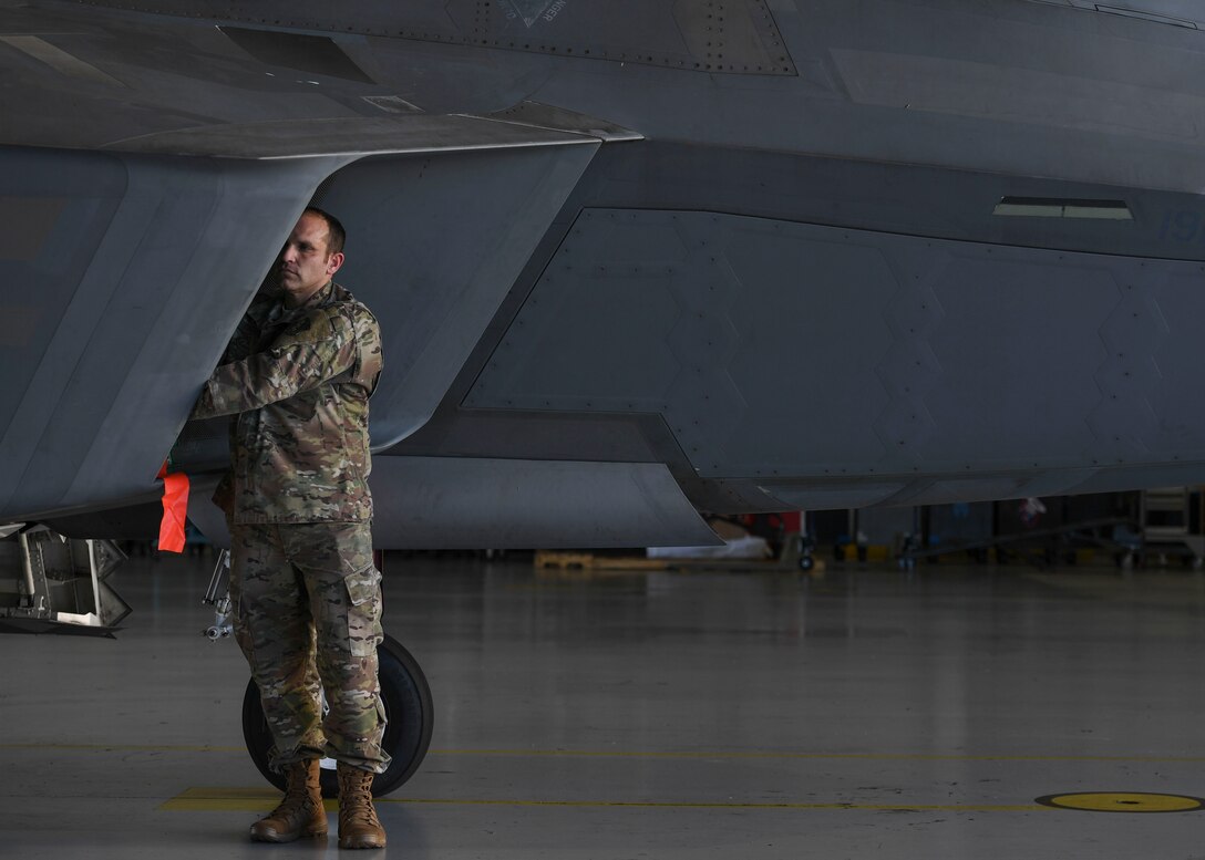 U.S. Air Force Tech. Sgt. Daniel Caban, 1st Aircraft Maintenance Squadron crew chief, covers an F-22 Raptor intake with the Portable Magnetic Aircraft Covers at Joint Base Langley-Eustis, Virginia, Oct. 23, 2019.