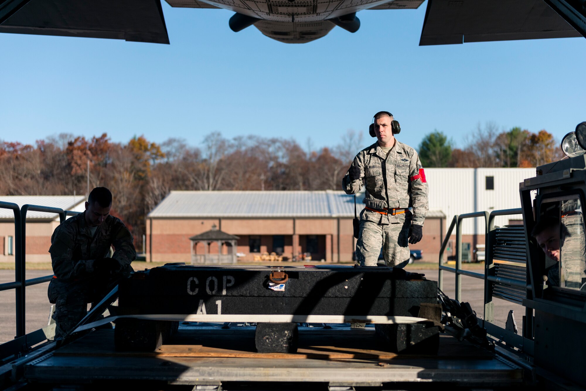 Staff Sgt. Richard Wood, 103rd Logistics Readiness Squadron air transportation craftsman, guides cargo onto a C-130H Hercules at Bradley Air National Guard Base, East Granby, Conn. Nov. 2, 2019. Air transportation specialists play a key role in supporting the 103rd Airlift Wing mission by assembling cargo pallets, rigging parachutes, and recovering these cargo pallets at the drop zone. (U.S. Air National Guard photo by Airman 1st Class Chanhda Ly)
