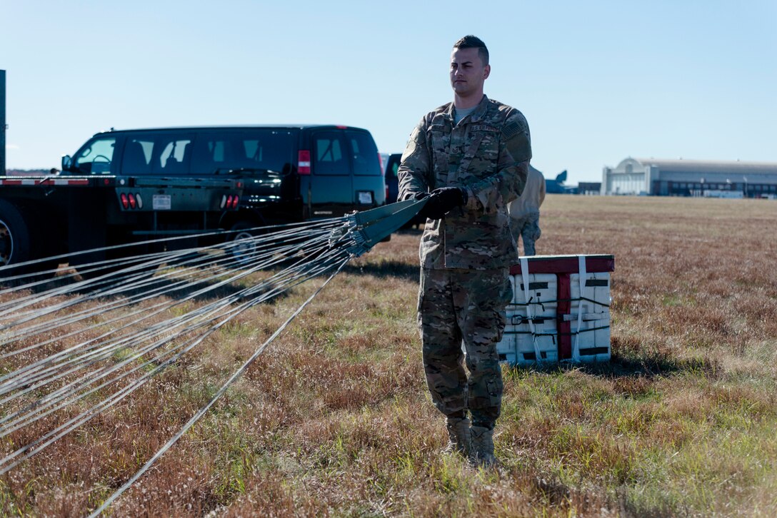 Tech. Sgt. Ryan Lester, 103rd Logistics Readiness Squadron air transportation craftsman, repacks a parachute after an airdrop at Westover Air Reserve Base, Chicopee, Mass. Nov. 2, 2019. The parachute used for the air drop is part of a low-cost, low-altitude pallet and can be thrown away after use. (U.S. Air National Guard photo by Airman 1st Class Chanhda Ly)